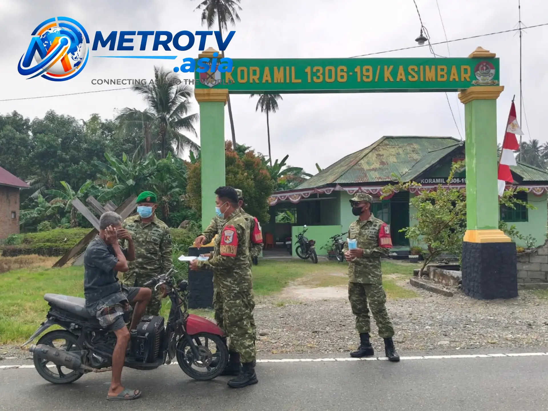 Personel Koramil 1306-19/Kasimbar membagikan masker kepada warga yang melintas di Jalan Trans Sulawesi, Desa Kasimbar Utara, Parigi Moutong, Senin 22 Oktober 2026
