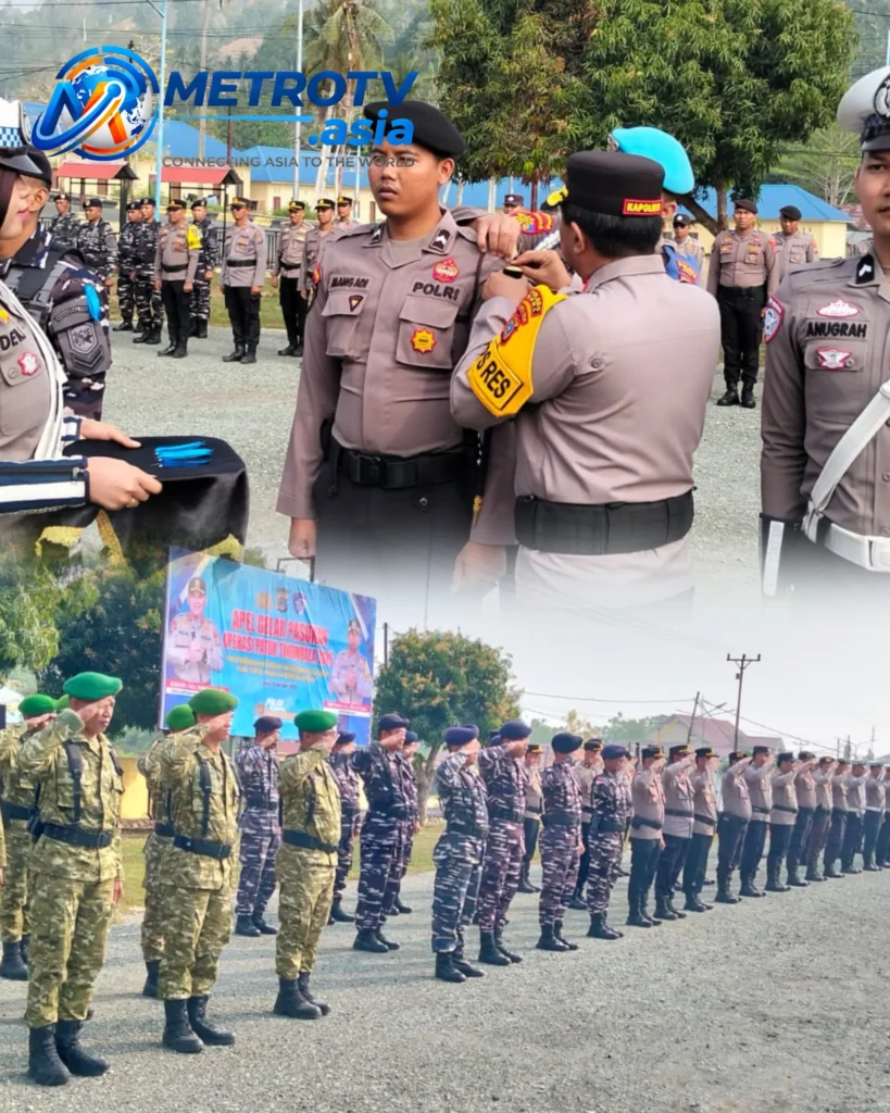 Atasan menyematkan pita tanda operasi kepada personel Polri, diiringi penghormatan barisan gabungan TNI-Polri saat Apel Gelar Pasukan Operasi Patuh Tinombala 2026 di Polres Buol, 26 Oktober 2026