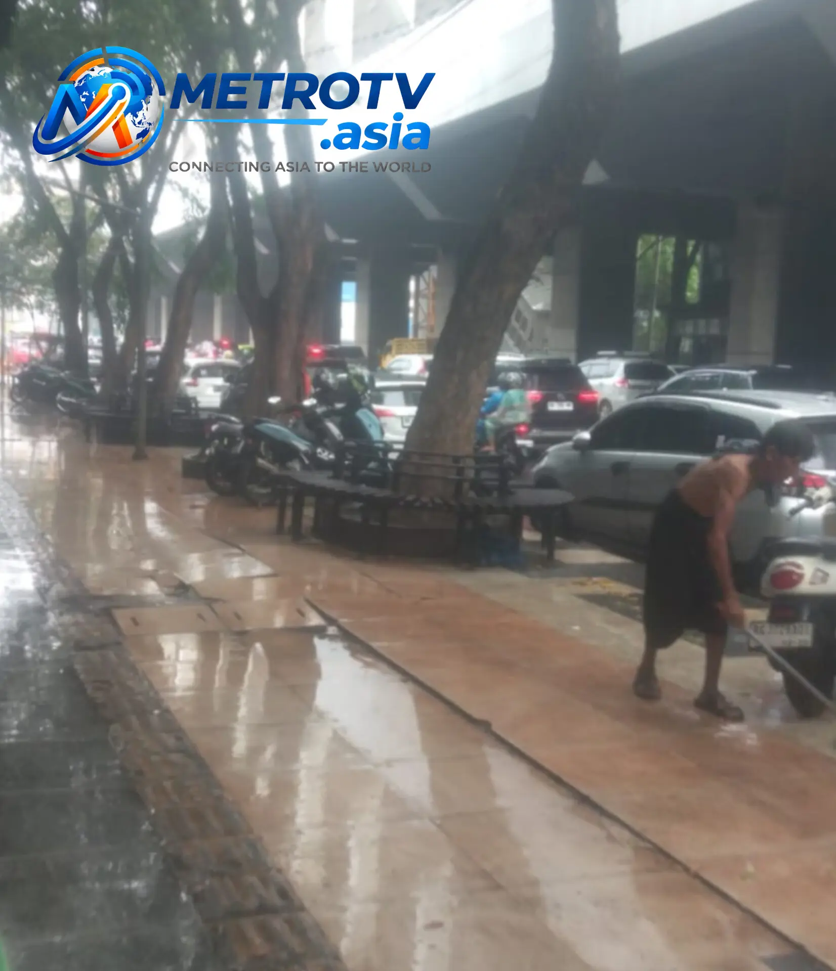 Seorang warga menyapu air hujan di trotoar Kota Palembang yang tergenang, Kamis 29 Oktober 2026. Hujan tiga hari berturut-turut membawa kesejukan sekaligus harapan kabut asap karhutla segera hilang.
